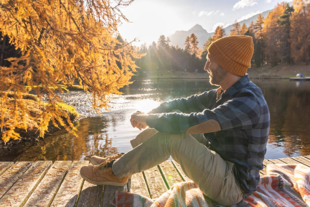 istock Man Relaxing by Tranquil Autumn Lake 2186051701