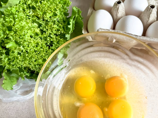 istock Raw eggs and lettuce. Egg tray. Cooking an omelet - eggs and herbs. yolk, white and white eggs. 2186056374