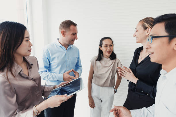 istock Professionals engage in collaborative discussion while reviewing a tablet in a modern office setting 2186062207