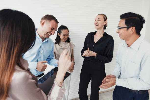 Group of professionals engaged in lively conversation in a modern office setting during the afternoon