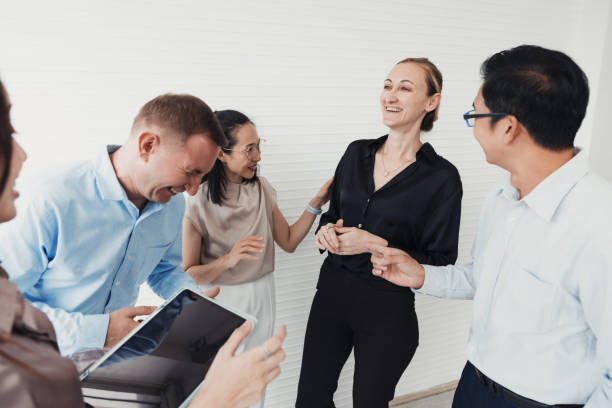 istock Group of professionals engaging in lively conversation at a modern office during a team-building event 2186062224