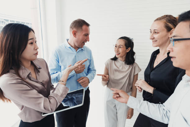 istock Group of professionals engaged in a lively discussion in a modern office setting during daylight hours 2186062233