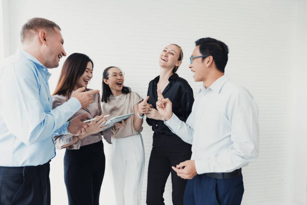 istock Group of colleagues laughing and collaborating in a bright office space during a team meeting in the afternoon 2186062592