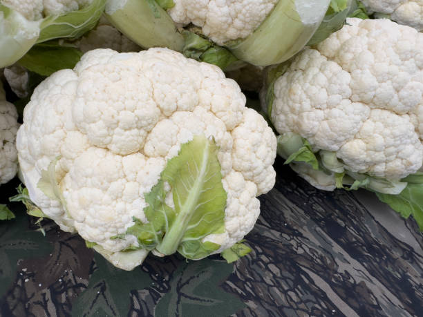 istock Cauliflower heads sitting on table with leaves trimmed 2186067186