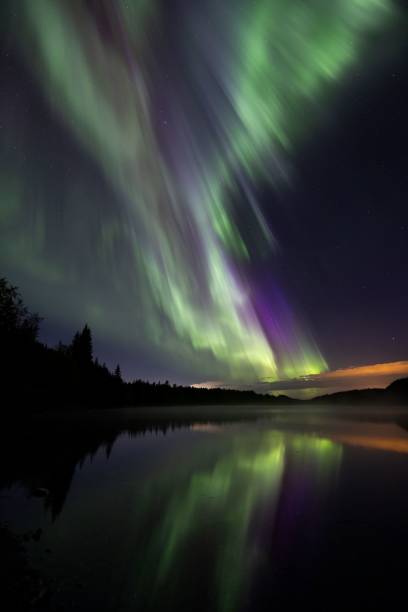 istock Burst of northern lights over a lake with reflection, Norway 2186084468