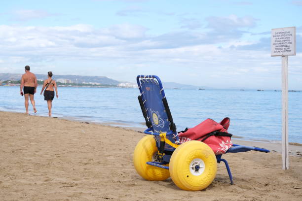 Pescara, Italy, about 2024. A beach wheelchair sits on the sandy shore, positioned close to the calm sea.