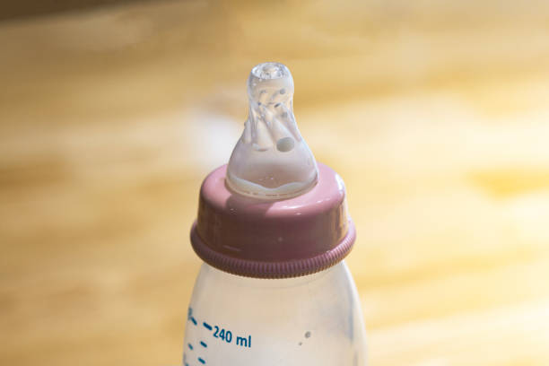 Bottle of milk for baby. Pink baby bottle nipples. Breast feeding concept.