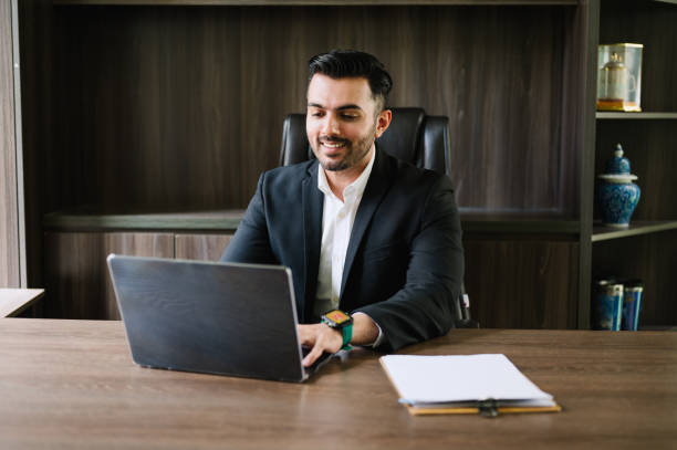 istock Happy Asian Indian businessman working alone in office. 2186094053