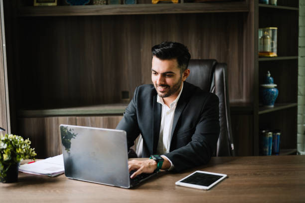 istock Happy Asian Indian businessman working alone in office. 2186094371