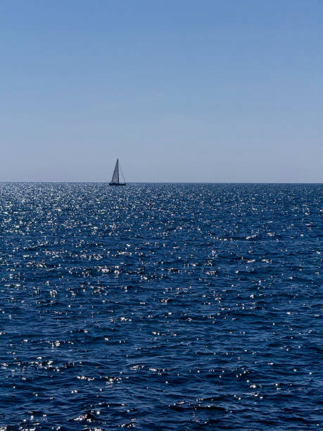 istock Sea blue sparkling water, sky and sailboat on horizon 2186095691