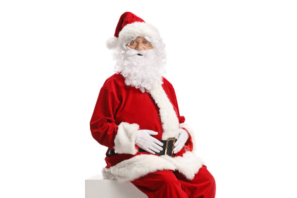 istock Santa claus sitting on a white cube and looking at camera 2186107333