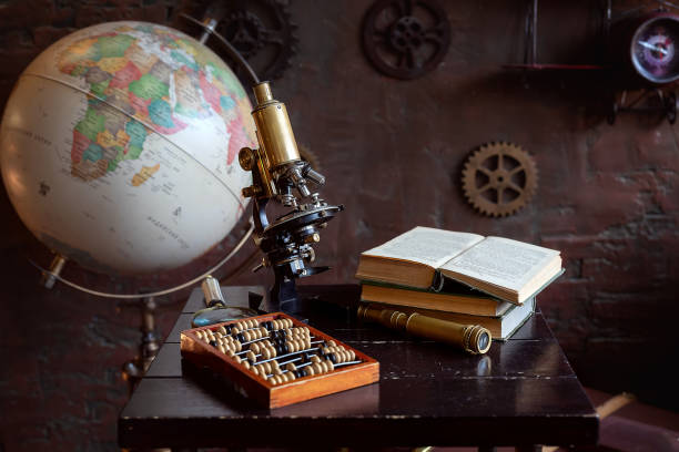 istock Vintage objects with a globe, microscope, and abacus on a wooden desk, symbolizing science and history 2186115319