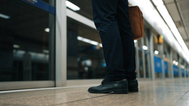 istock Skilled business man standing or waiting for train while holding bag. Exultant. 2186115448