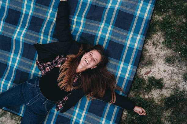 istock An happy woman is lying down on a blanket 2186116785