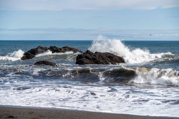 istock Waves crashing against rocks on a sunny beach. 2186118694