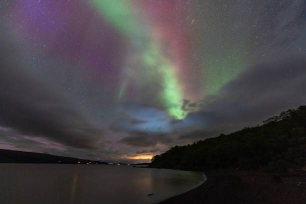 Aurora borealis over a serene lake with vibrant hues.