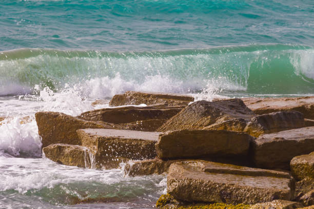 closeup emerald sea bay with stony coast
