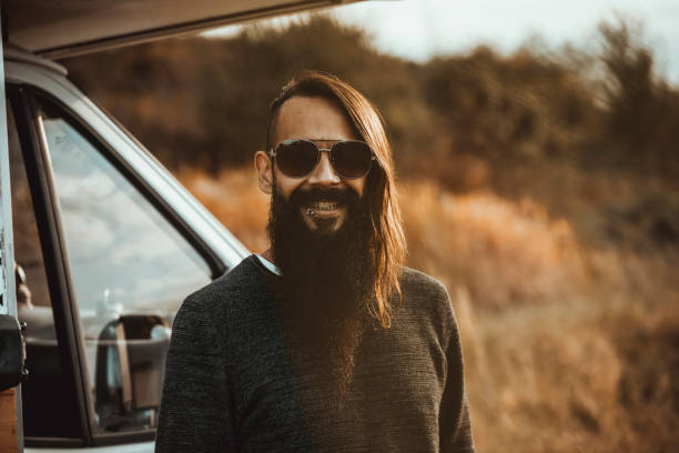 Close-up portrait of Brazilian guy with sunglasses outdoors looking at camera smiling
