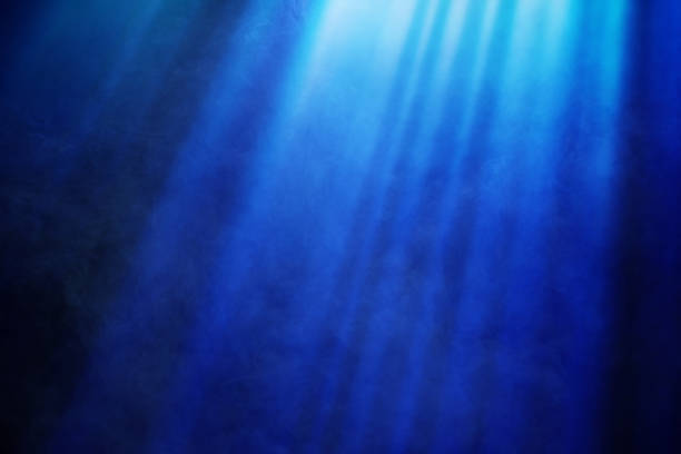 istock Mystical Blue Light Rays Cutting Through Smoke Atmosphere on a Deep Blue Background 2186133950