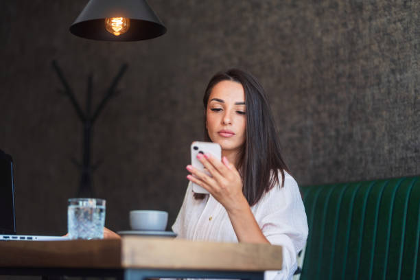 istock Focused businesswoman using smartphone in cafe 2186137157