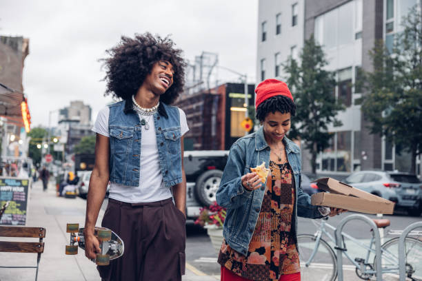 istock Two friends eating pizza on the street 2186137380