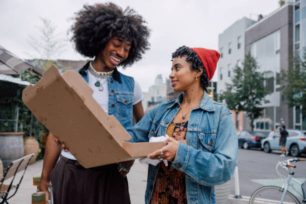 istock Two friends eating pizza on the street 2186137675