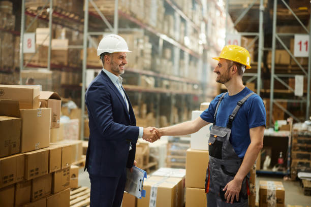 istock Happy inspector greeting with manual worker in storage room. 2186144121