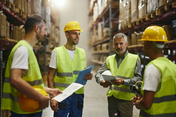 istock Male inspector and manual workers talking in storage room. 2186148023