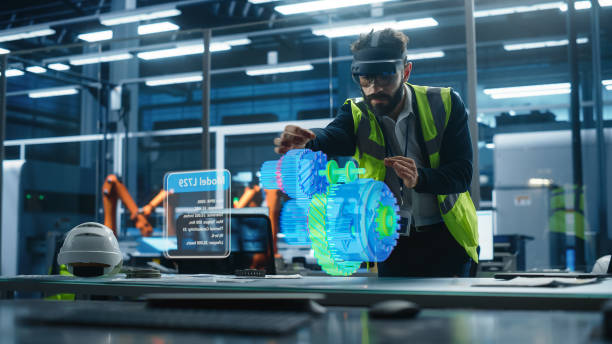istock Male Engineer Uses an Augmented Reality Headset to Interact With 3D Holographic Model of Engine in a High Tech Factory, Showcasing Innovative Manufacturing Processes, Advanced Digital Visualization 2186167901