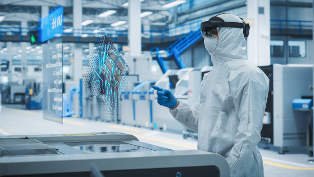 istock Sterile Coverall Wearing Engineer Uses Augmented Reality Headset to Interact With 3D Holographic Model of Silicon Microchip in Manufacturing Plant, Engineering of Personal Computer Hardware 2186168329
