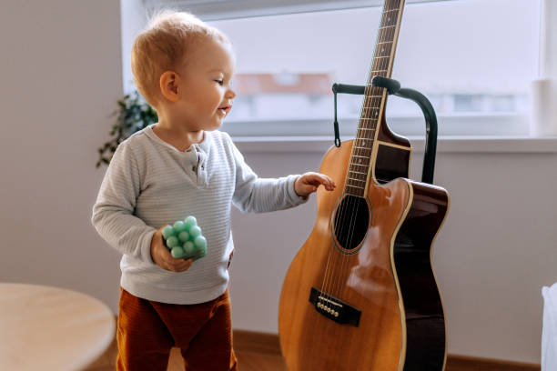 Two young boys sitting back to back, joyfully playing music with a harmonica and guitar, sporting trendy hats and cool sunglasses, embodying the spirit of childhood fun and creativity