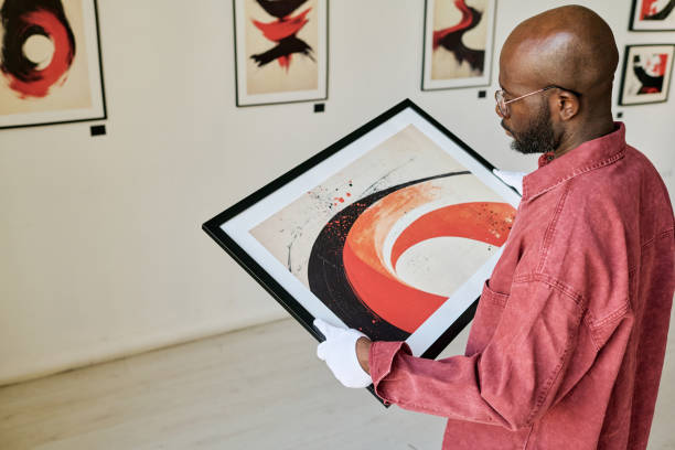 istock Man Examining Abstract Painting in Art Gallery 2186177836
