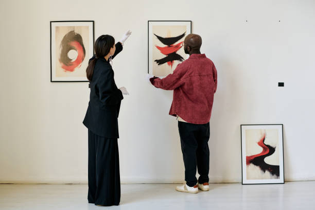 istock Viewers Discussing Abstract Art in Minimalistic Gallery 2186179504