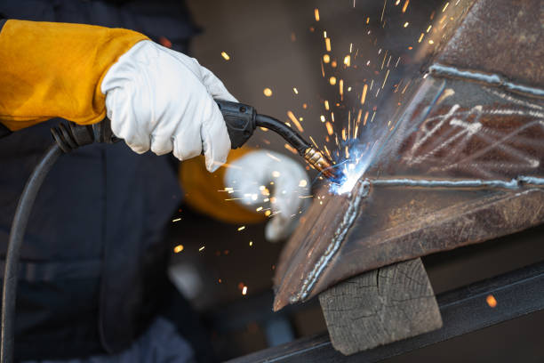 istock Worker welding metal with sparks flying in workshop 2186179595