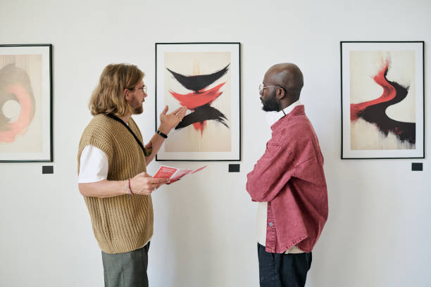 istock Discussing Abstract Art Painting in Gallery Setting 2186179697
