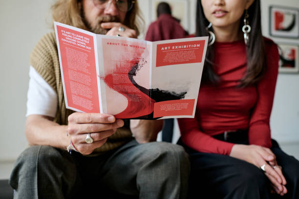 istock Discussing Art Exhibition Pamphlet While Sitting Together 2186179773