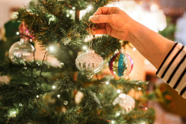 istock Close up to hands hanging knick knacks on Christmas tree. 2186190499