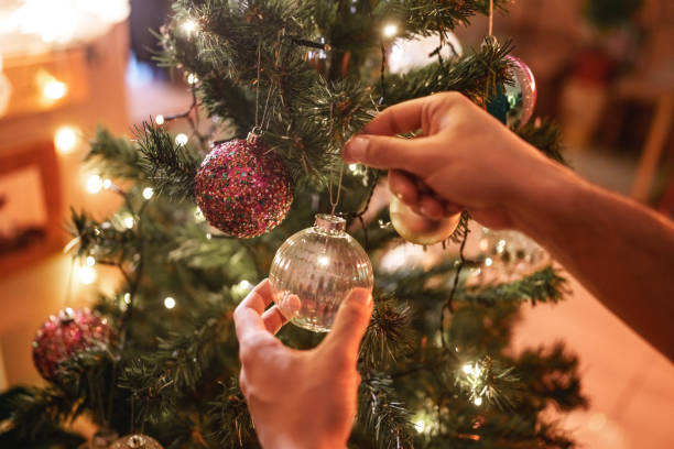 istock Close up to hands hanging knick knacks on Christmas tree. 2186195843