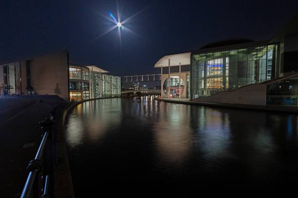 Night view of the Berlin government district with illuminated modern architecture reflected in the Spree in winter