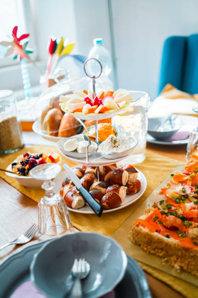 istock Beautiful Breakfast Table Setting With Diverse Delicious Foods Including Fresh Fruit Platter, Savory Pastries, And Pretzels In A Dining Area Lit By Sunshine 2186197619