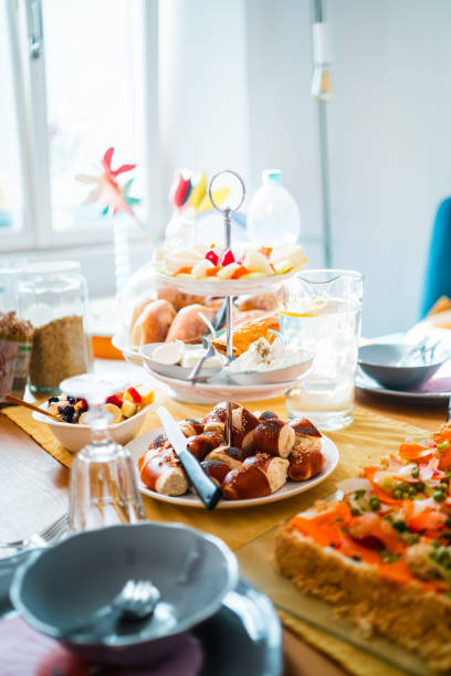 istock Elegant Breakfast Table Setting With Various Delicious Foods Including Fresh Fruit Platter, Savory Pastries, And Pretzels In A Bright, Sunlit Dining Area 2186198543