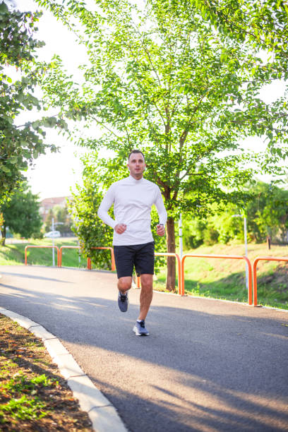 istock Young man running in the park during sunny autumn day 2186198854