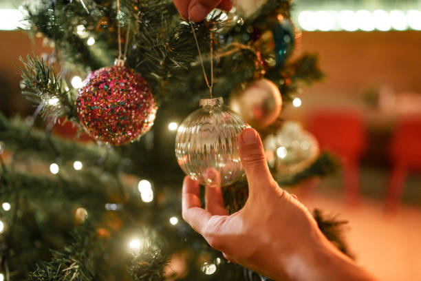 istock Close up to hands hanging knick knacks on Christmas tree. 2186199543