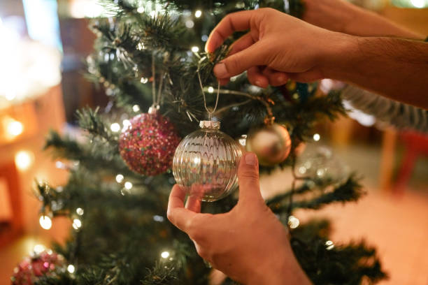 istock Close up to hands hanging knick knacks on Christmas tree. 2186199545