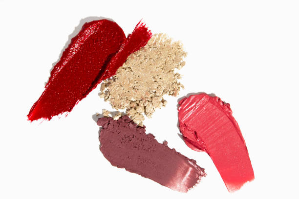 istock Cosmetic texture featuring eyeshadow, lipstick, lip gloss, and scattered pigments. A beauty composition. 2186206142