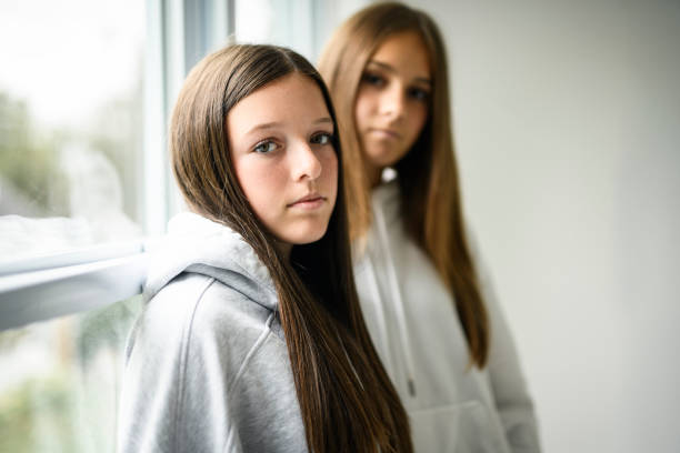 Nice Two best girlfriends together on white studio wearing hoodies
