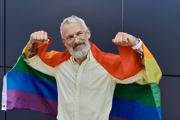 istock Joyful mature man celebrates pride with a rainbow flag in a vibrant urban setting 2186214474