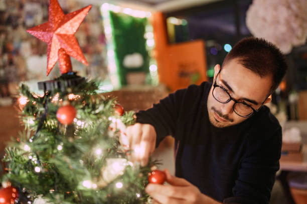istock Man decorating a Christmas tree, new year celebration. 2186216308