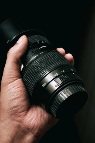 istock A person's hand holding a DSLR lens in low light 2186222714