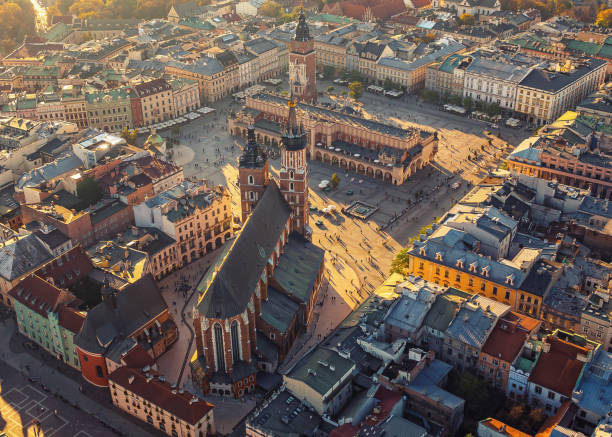 Krakow's central square from drone in sunset light. Main Market Square with Town Hall, Cloth Hall and St. Mary's Basilica